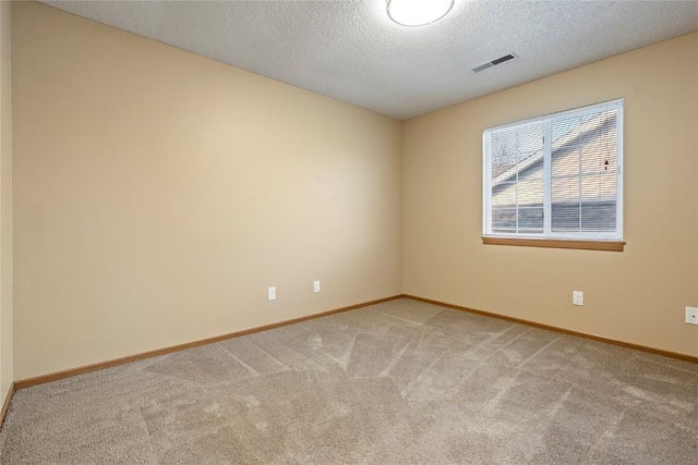 carpeted spare room with a textured ceiling