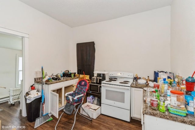 kitchen featuring white cabinets, dark wood-type flooring, electric range, and dark stone counters