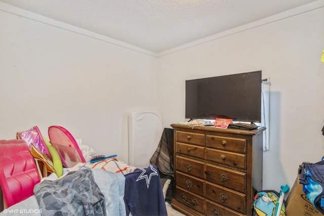 bedroom featuring ornamental molding and a textured ceiling