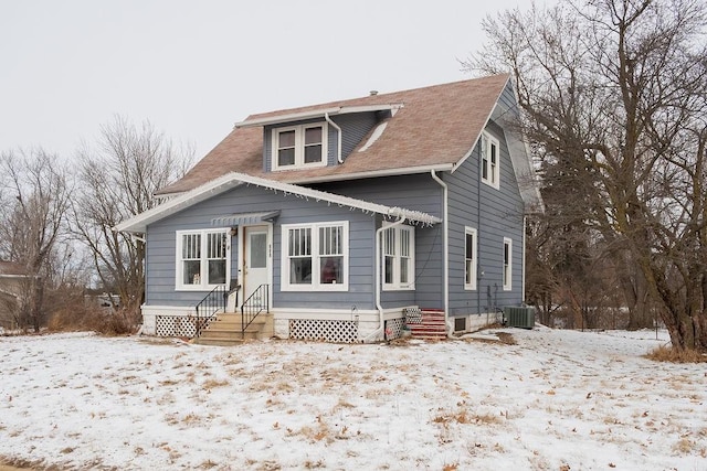 bungalow-style home with cooling unit, a shingled roof, and entry steps