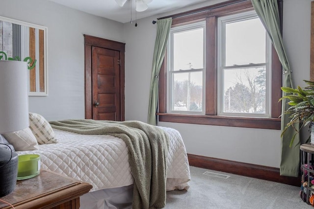 carpeted bedroom with multiple windows, baseboards, and visible vents