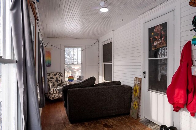 living room with wooden walls, dark hardwood / wood-style floors, and ceiling fan