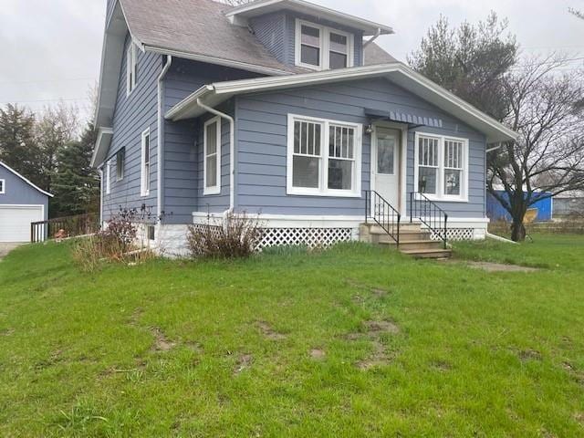 bungalow-style home with an outbuilding, entry steps, and a front yard