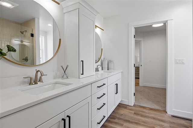 bathroom featuring a shower with door, vanity, and hardwood / wood-style floors