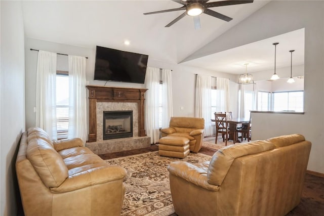 living room featuring a premium fireplace, vaulted ceiling, a healthy amount of sunlight, and ceiling fan