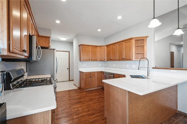 kitchen with dark hardwood / wood-style floors, pendant lighting, sink, kitchen peninsula, and stainless steel appliances