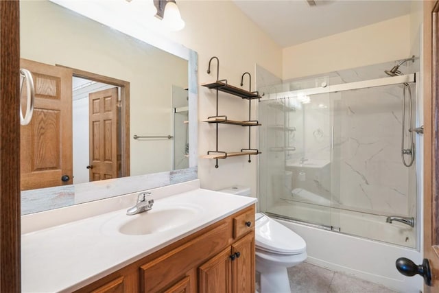 full bathroom featuring vanity, combined bath / shower with glass door, tile patterned floors, and toilet