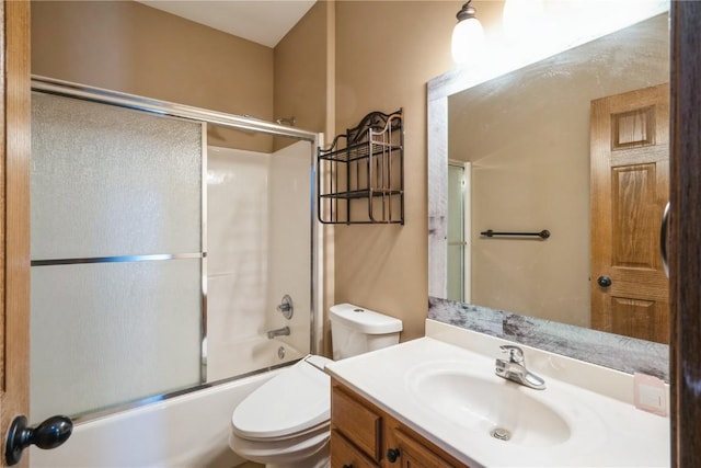 full bathroom with bath / shower combo with glass door, vanity, and toilet