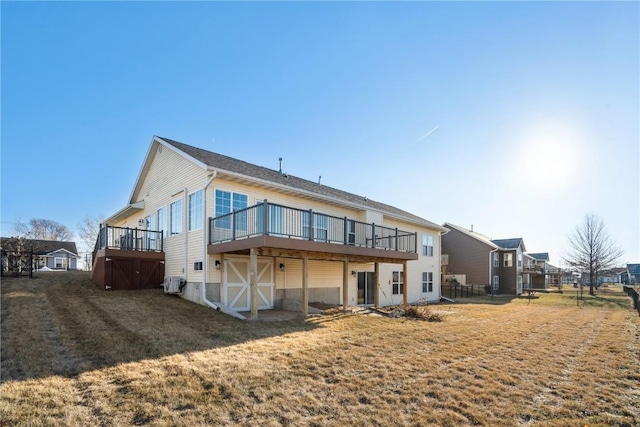 rear view of property with a wooden deck and a yard