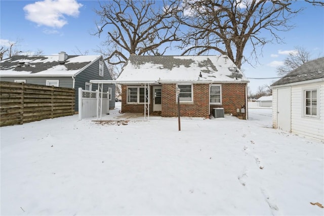 snow covered back of property with central air condition unit