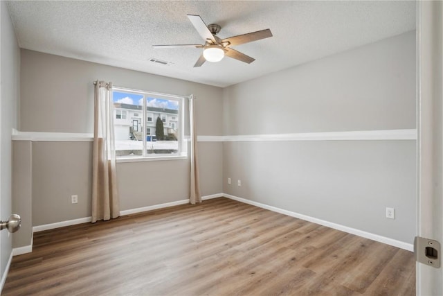 unfurnished room featuring a textured ceiling, wood-type flooring, and ceiling fan