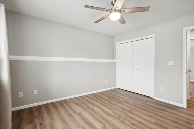 unfurnished bedroom with hardwood / wood-style flooring, a closet, and ceiling fan