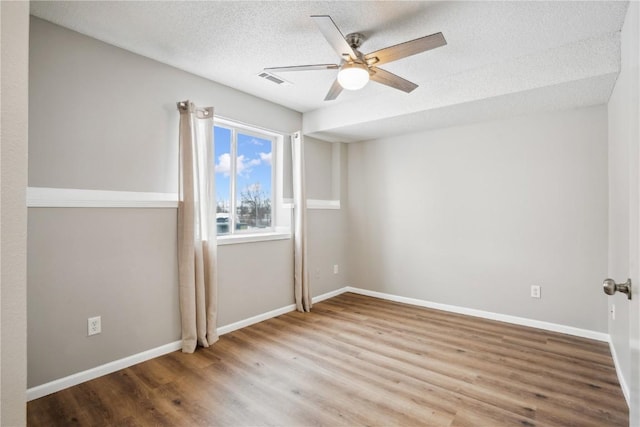 spare room featuring ceiling fan, hardwood / wood-style floors, and a textured ceiling