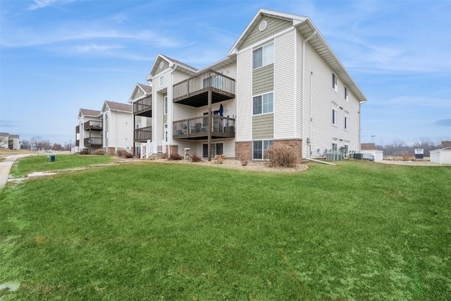 back of property with central air condition unit and a lawn