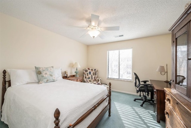 carpeted bedroom featuring ceiling fan and a textured ceiling