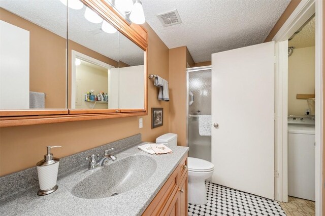 bathroom with toilet, an enclosed shower, a textured ceiling, vanity, and washer / clothes dryer