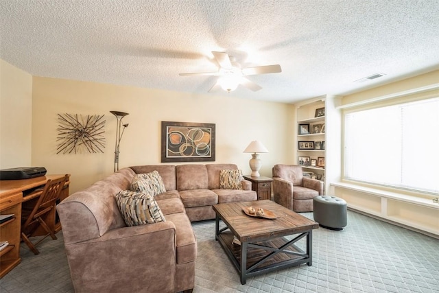 carpeted living room featuring a textured ceiling and ceiling fan