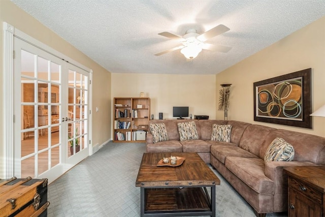 living room featuring ceiling fan, a textured ceiling, and french doors