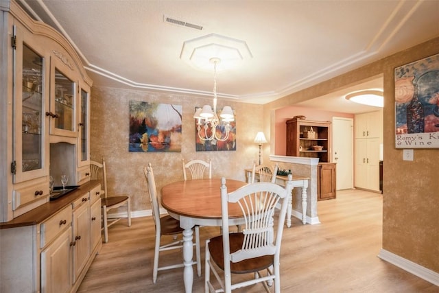 dining space featuring an inviting chandelier and light hardwood / wood-style floors