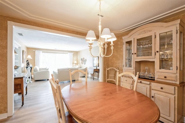 dining area featuring a notable chandelier and light hardwood / wood-style floors