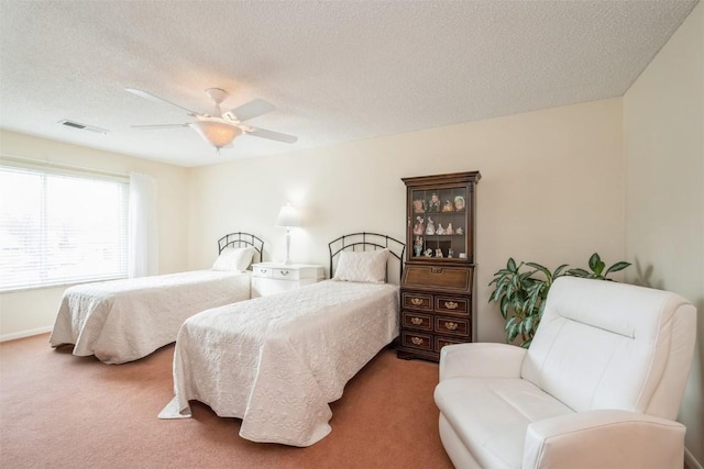 bedroom with ceiling fan, carpet flooring, and a textured ceiling