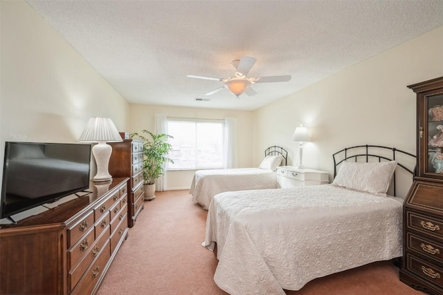 carpeted bedroom featuring ceiling fan and a textured ceiling