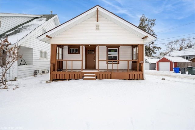 bungalow-style home featuring an outbuilding, a garage, and covered porch