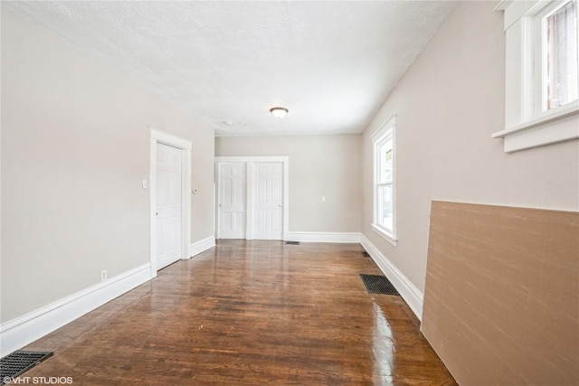 empty room featuring dark wood-type flooring and a textured ceiling