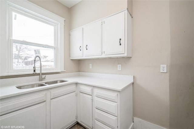 kitchen featuring sink and white cabinets