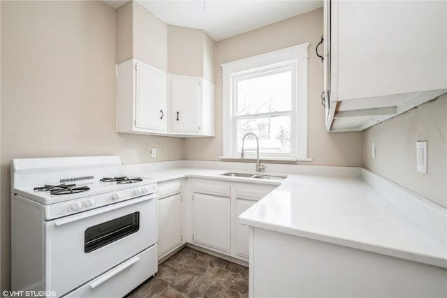 kitchen featuring white cabinetry, sink, and white range with gas stovetop