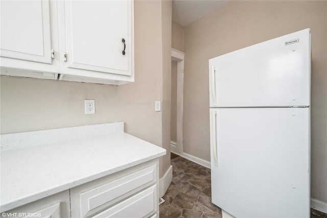 kitchen featuring white refrigerator and white cabinetry