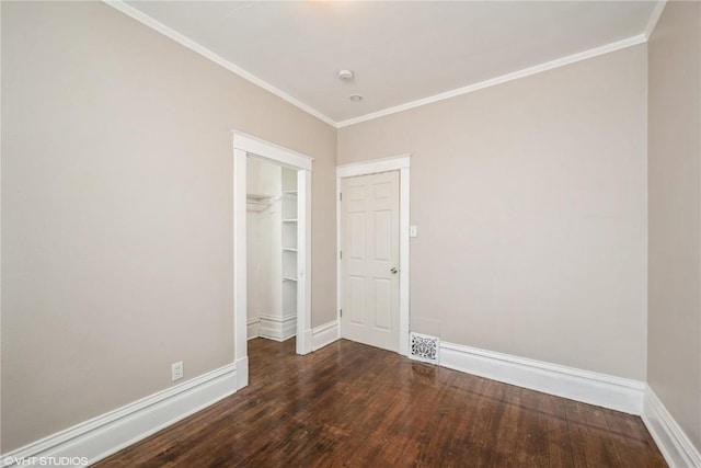 empty room with dark hardwood / wood-style flooring and ornamental molding