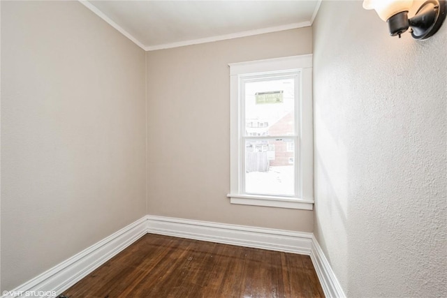 empty room featuring crown molding, a healthy amount of sunlight, and hardwood / wood-style floors