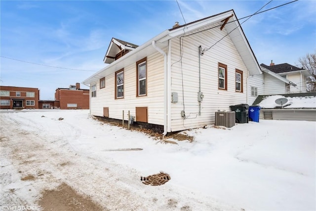 view of snow covered exterior featuring central AC unit