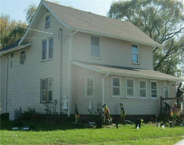 back of house featuring central AC unit and a yard