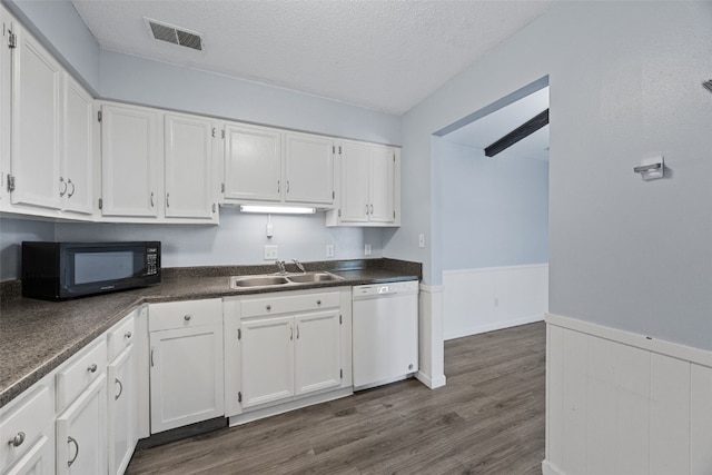 kitchen with white cabinetry, dishwasher, sink, and a textured ceiling