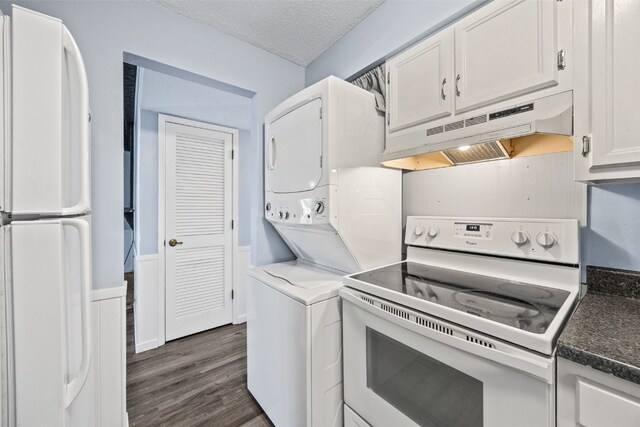 kitchen featuring stacked washing maching and dryer, white cabinetry, white appliances, dark wood-type flooring, and a textured ceiling