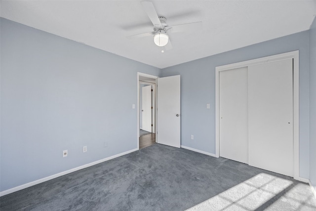 unfurnished bedroom featuring dark colored carpet, ceiling fan, and a closet