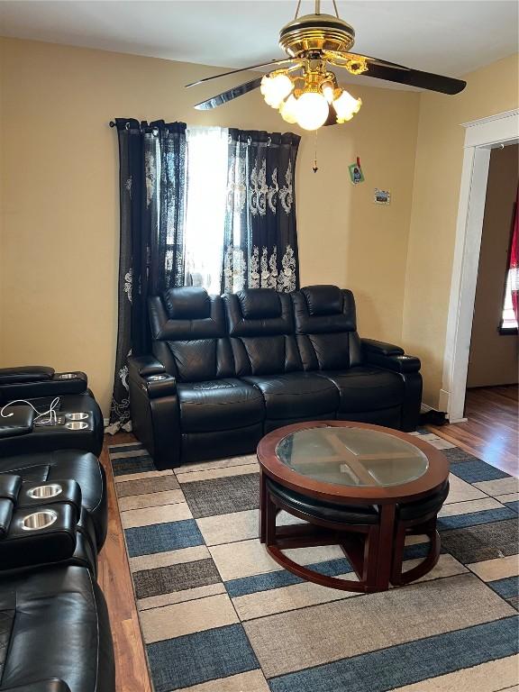 living area featuring ceiling fan, plenty of natural light, and wood finished floors