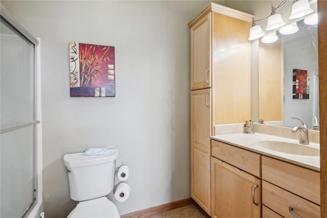 bathroom with vanity, toilet, and a shower with shower door