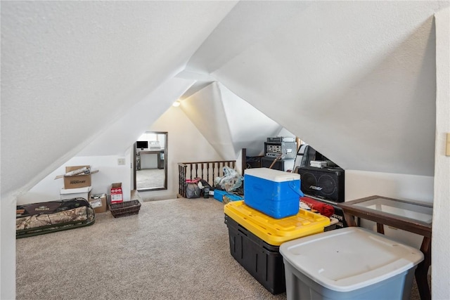 rec room with vaulted ceiling, a textured ceiling, and carpet flooring