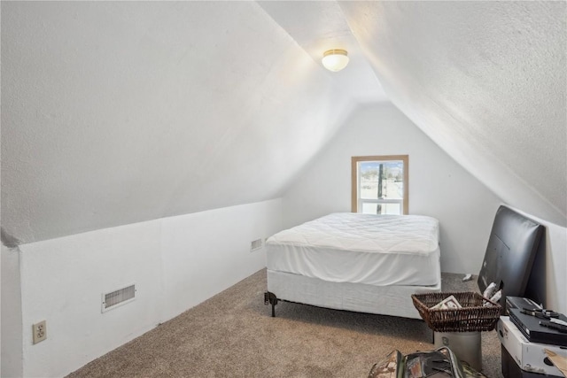 bedroom with lofted ceiling, carpet, and a textured ceiling