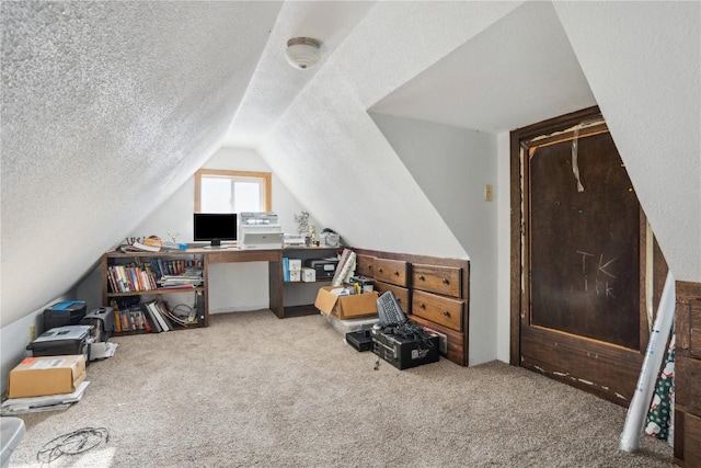 carpeted home office featuring lofted ceiling and a textured ceiling