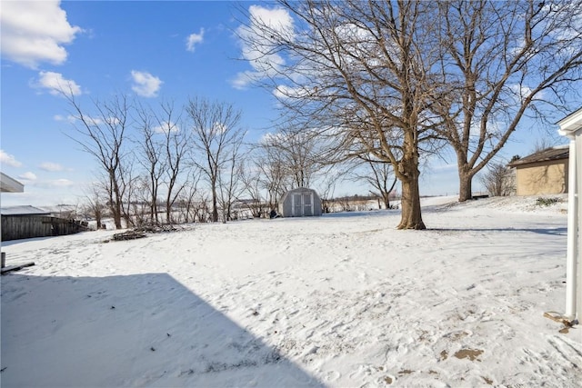 yard layered in snow featuring a storage shed