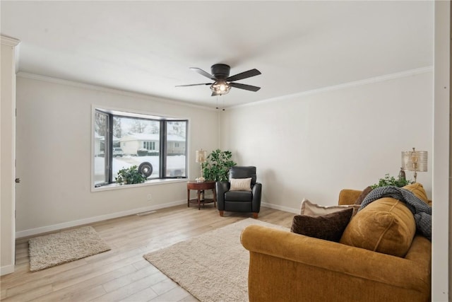 living area with ornamental molding, ceiling fan, and light hardwood / wood-style floors