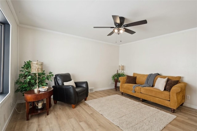 living room featuring ceiling fan, ornamental molding, and light wood-type flooring