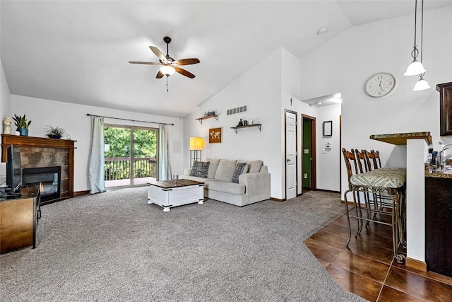 carpeted living room with ceiling fan, high vaulted ceiling, and a fireplace