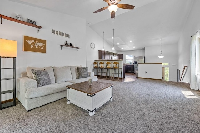 living room with ceiling fan, carpet, and high vaulted ceiling