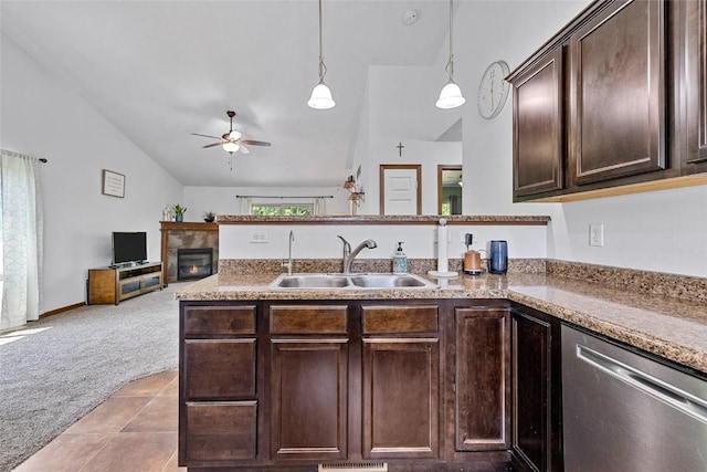 kitchen featuring decorative light fixtures, sink, stainless steel dishwasher, dark brown cabinetry, and light carpet