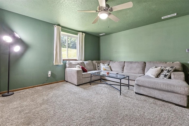 carpeted living room featuring ceiling fan and a textured ceiling